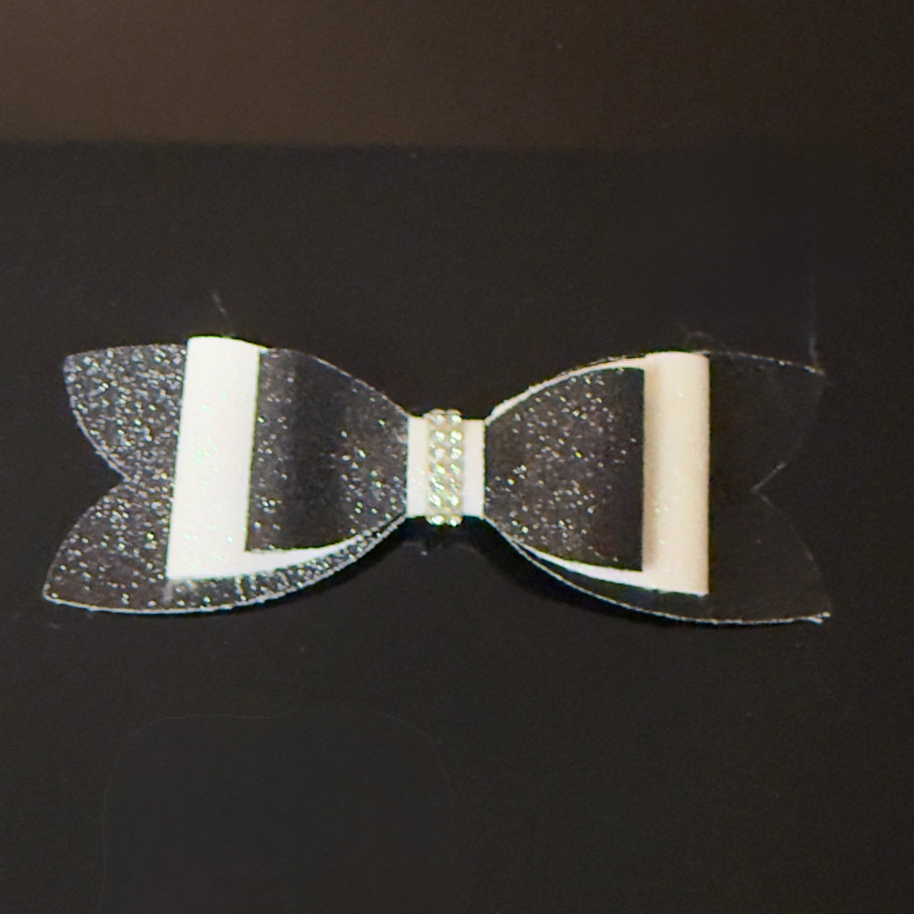 Black and white bow with glitter on a black background