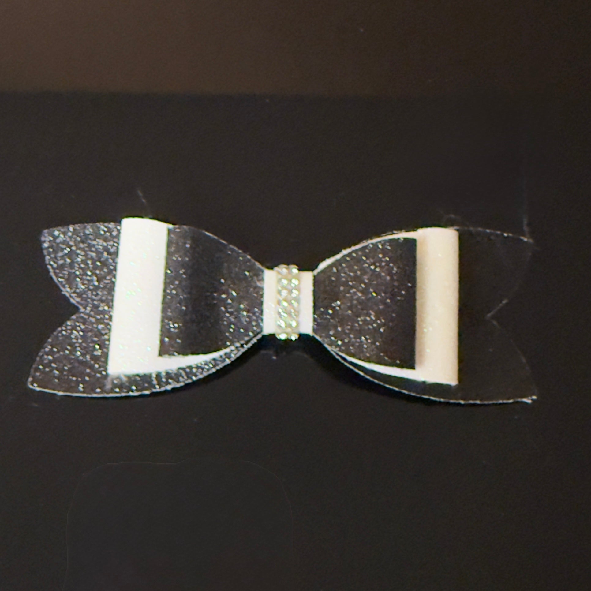 Black and white bow with glitter on a black background