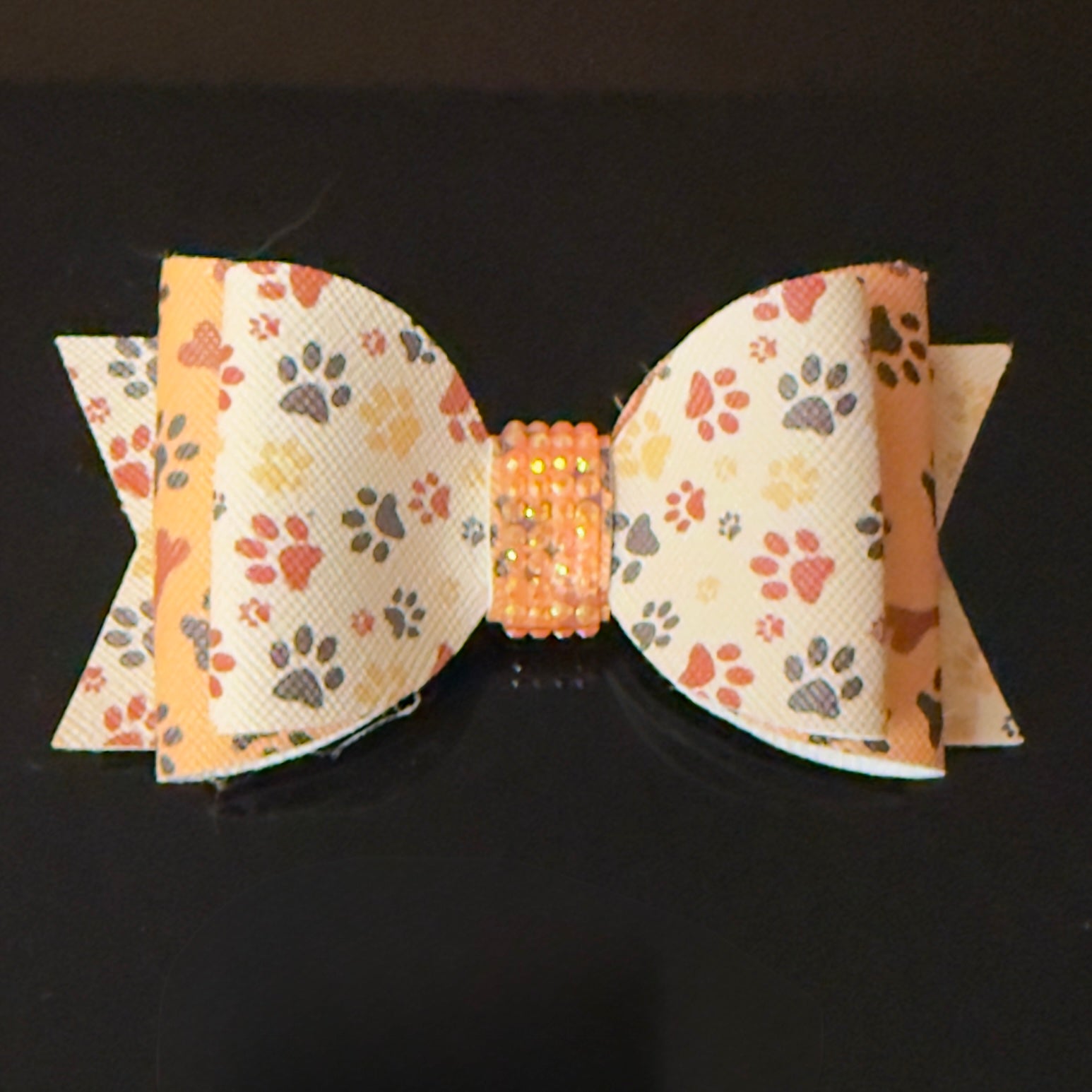 Bow with paw print pattern on a dark background