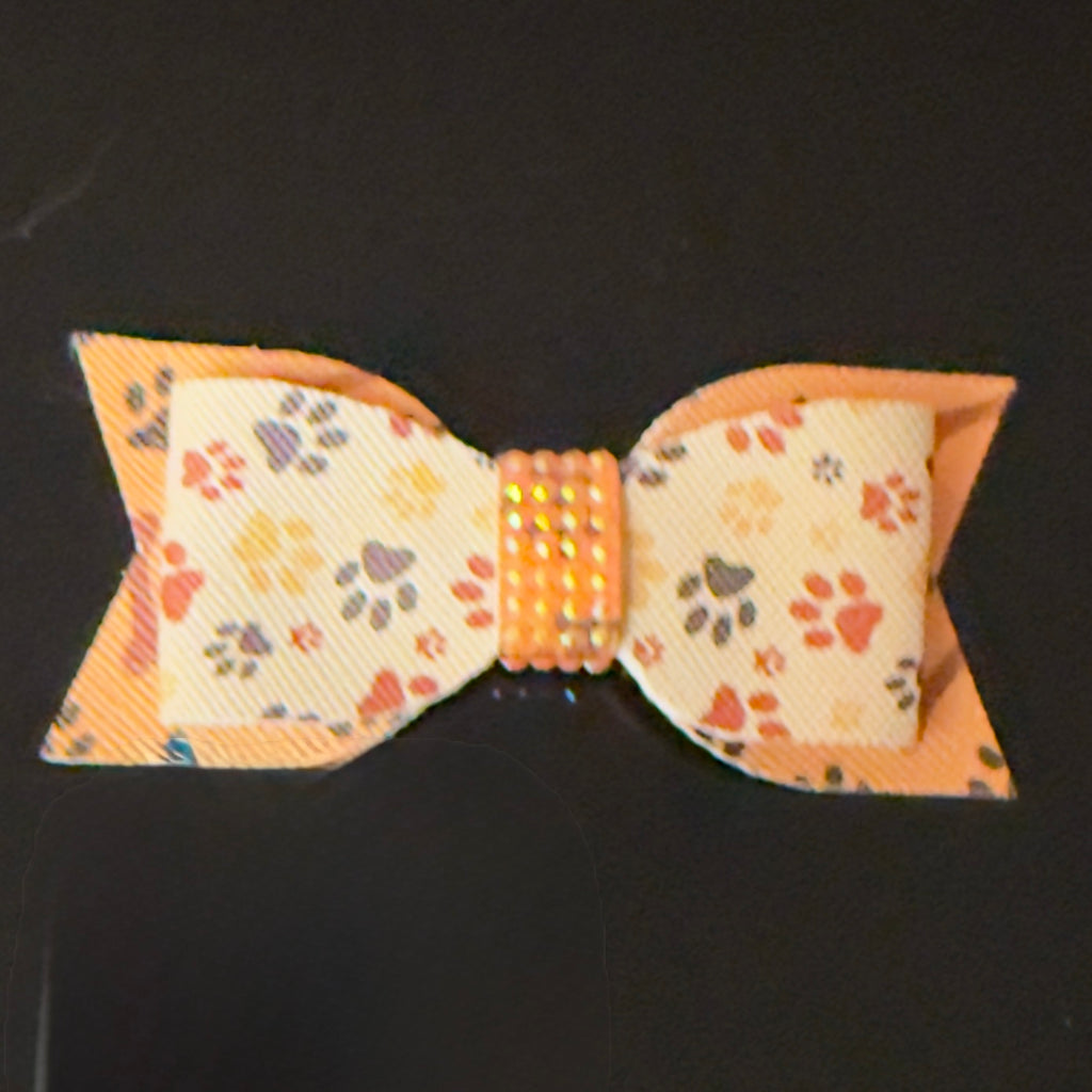 Bow tie with paw print pattern on a black background