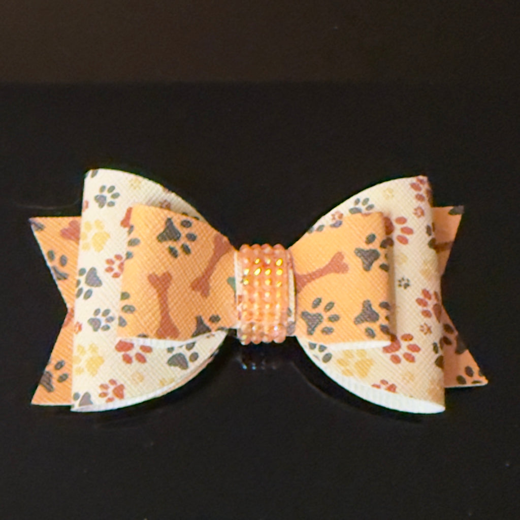 Dog bow tie with paw print pattern on a black background