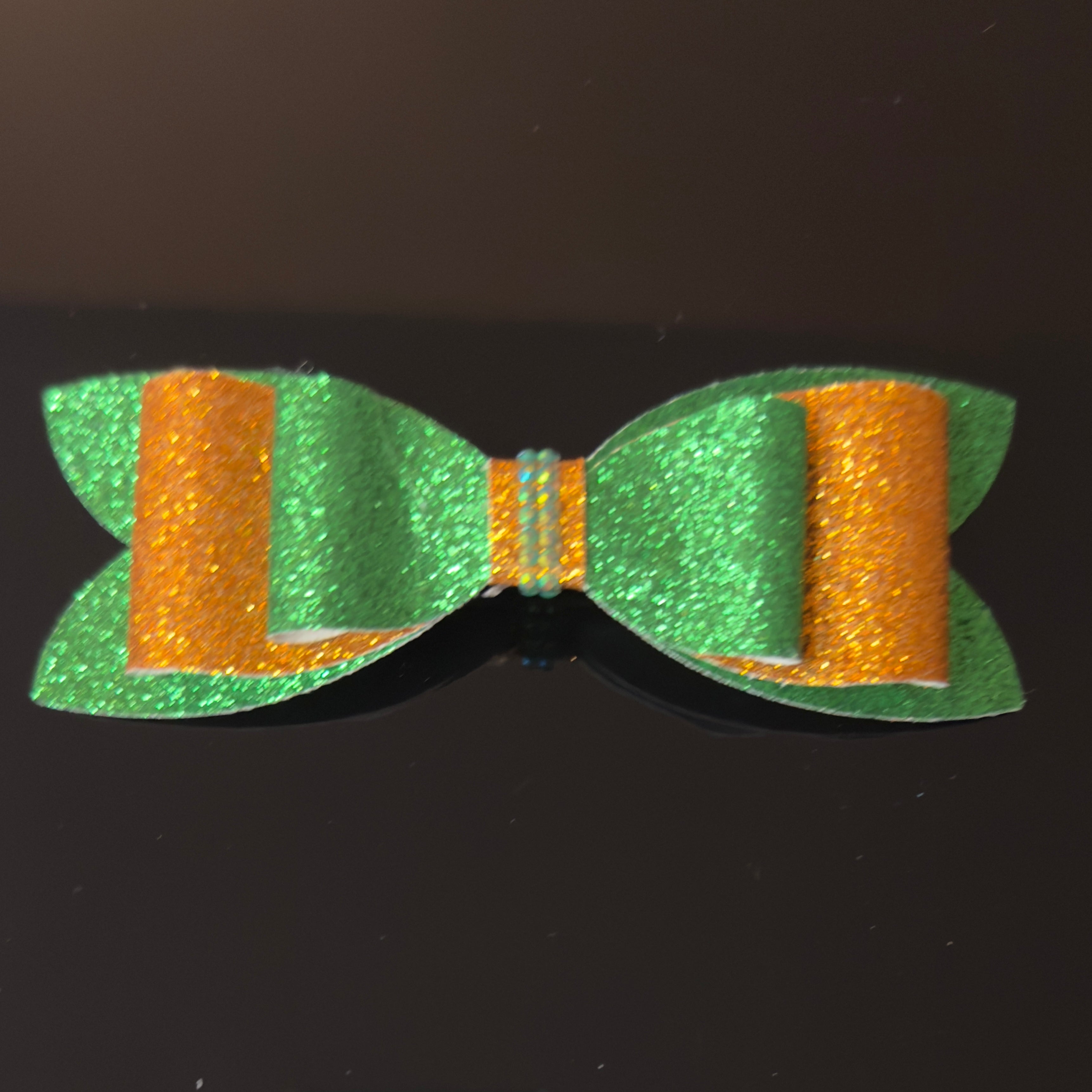 Green and orange glittery bow on a black background