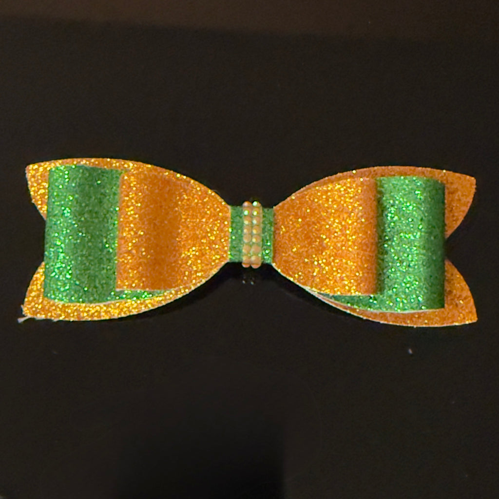 Glittery green and orange bow on a black background