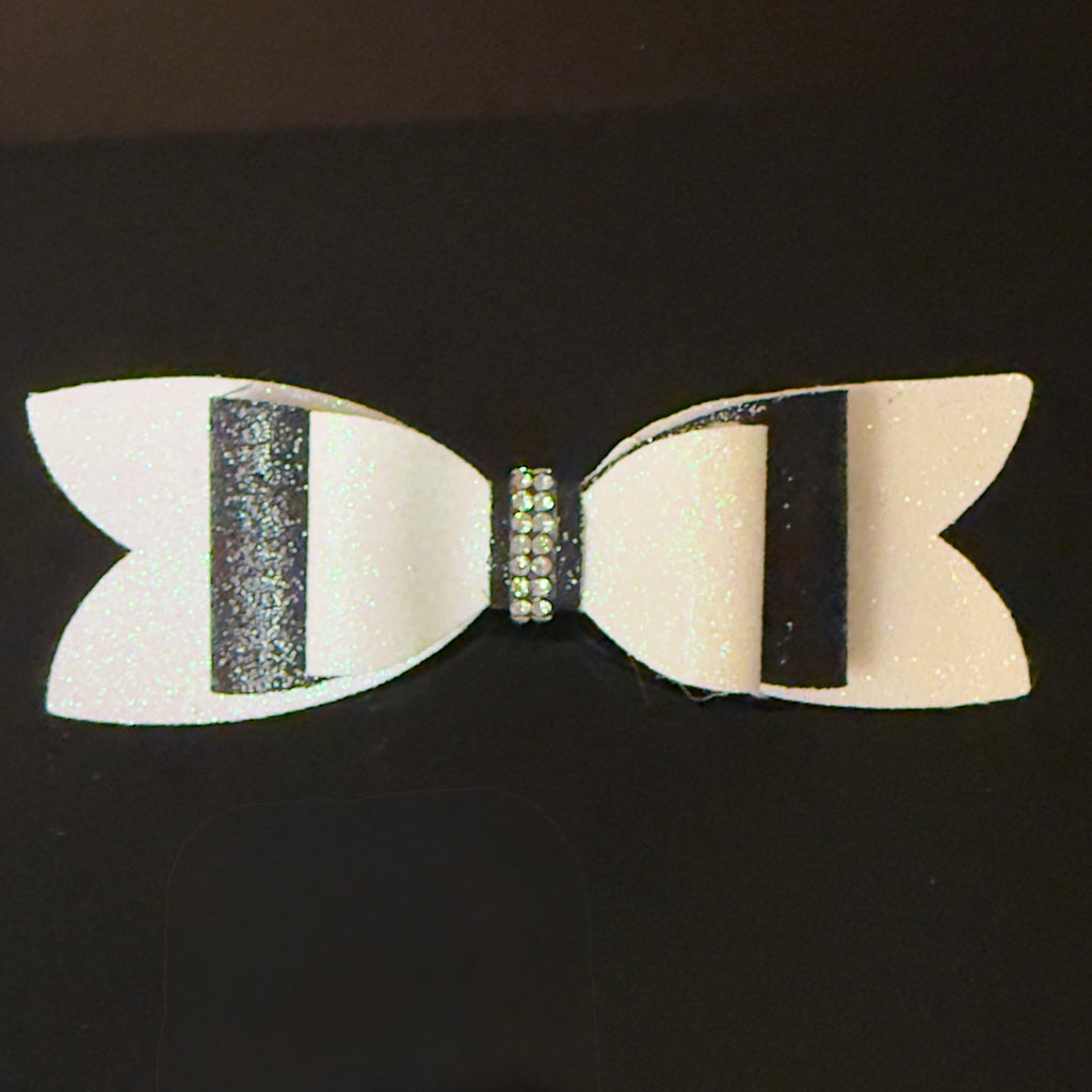 White bow with black center and rhinestone on a black background